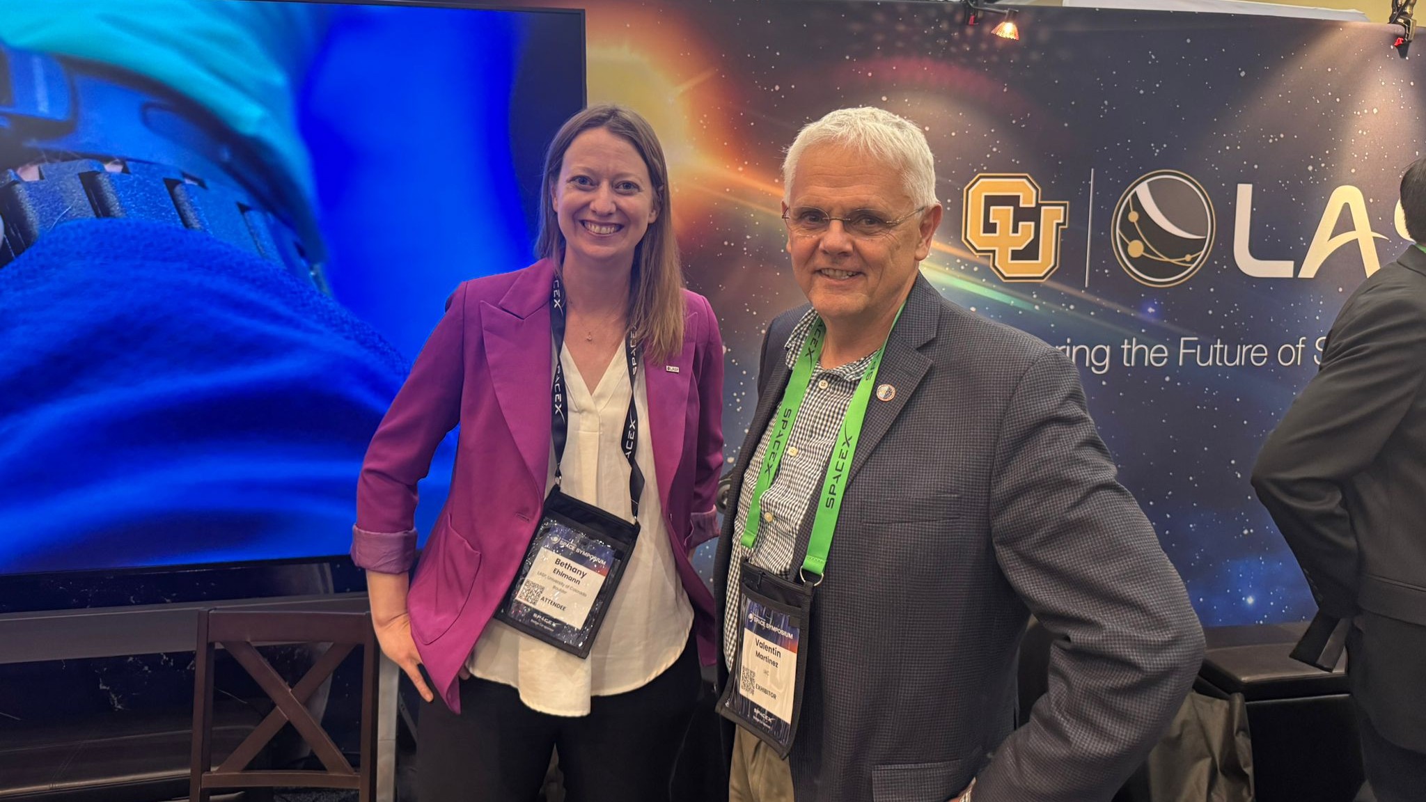 Bethany Ehlmann, directora de LASP, y Valentín Martínez Pillet, director del Instituto de Astrofísica de Canarias (IAC), posan juntos en el Space Symposium 2026, delante del expositor de LASP y la Universidad de Colorado.