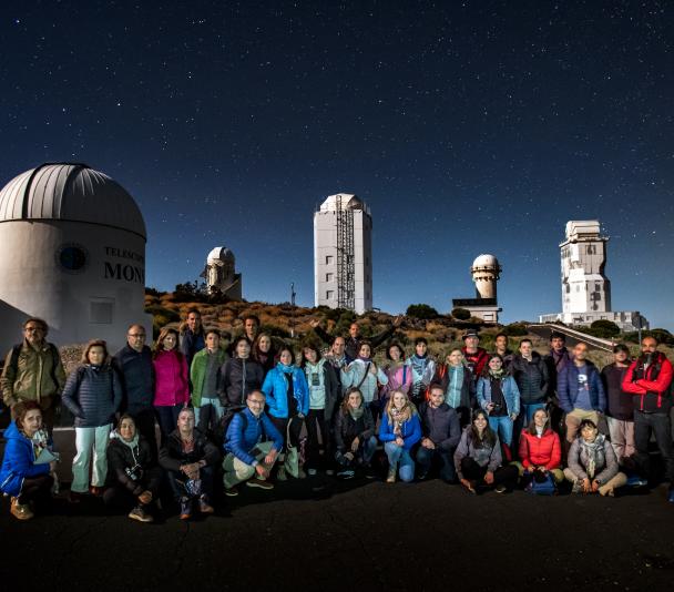 Teachers during night time observation with the solar towers at background
