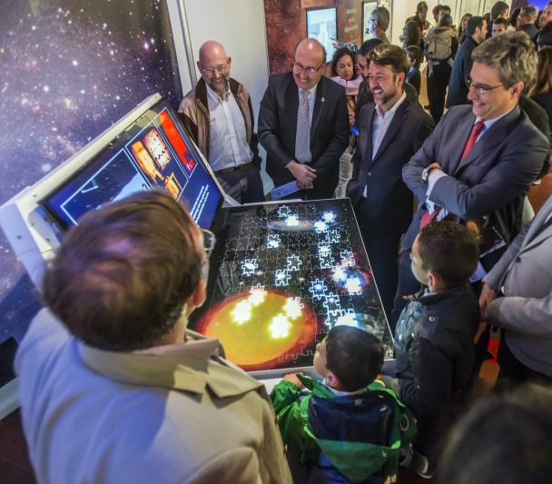 El director del IAC, Rafael Rebolo, el presidente del Cabildo de Tenerife, Carlos Alonso, el director de la ACIISI, Juan Ruiz Alzola, y el Director General de Cultura del Gobierno de Canarias, Xerach Gutiérrez Ortega, con los comisarios de la exposición "Luces del Universo" y público general en el módulo sobre "Hitos científicos del IAC".