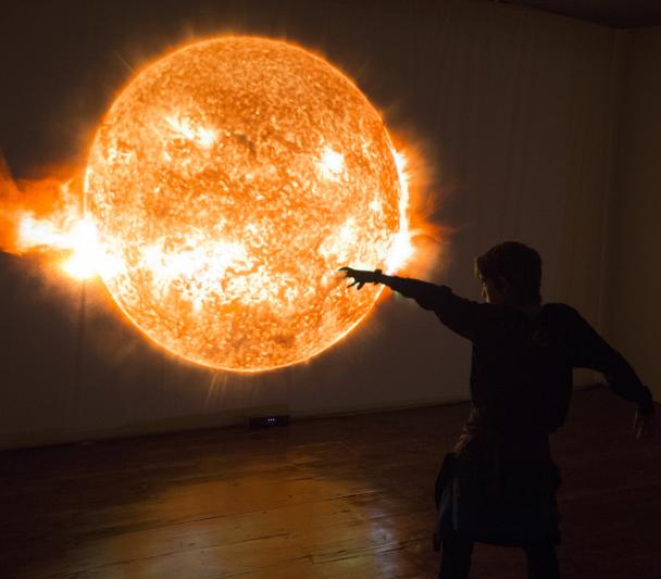 A child playing in front of the interactive module "Solar Immersion" in the "Lights of the Universe" exhibition. Credits: Daniel López/IAC. 