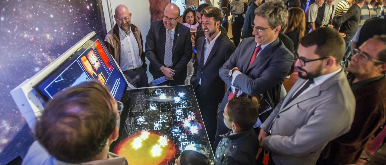 The Director of the IAC, Rafael Rebolo, the President of the Cabildo of Tenerife, Carlos Alonso, the director of the ACIISI, Juan Ruiz Alzola, and the Director General of Culture of the Canarian Government, Xerach Gutiérrez Ortega, with the Curators of the "Lights of the Universe" Exhibition, together with members of the public in the module "Scientific Highlights of the IAC".