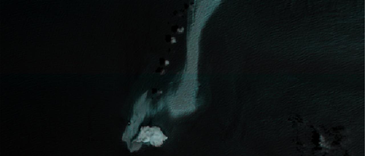 Imagen satelital en falso color del mar Arábigo en la que se aprecia una extensa mancha clara de petróleo junto al buque Caroline Bezengi y cerca de una isla del archipiélago omaní de Al Hallaniyat.
