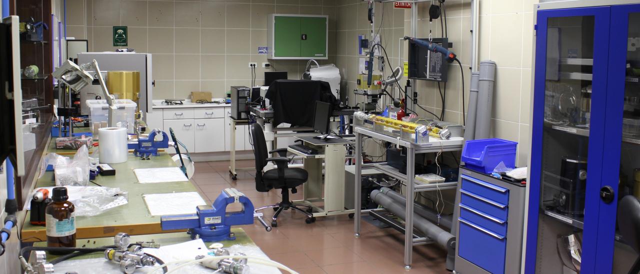 Vista general del laboratorio de integración mecánica. Laboratorio de tamaño mediano con bancos de trabajo, aparatos electrónicos, herramientas mecánicas y armarios