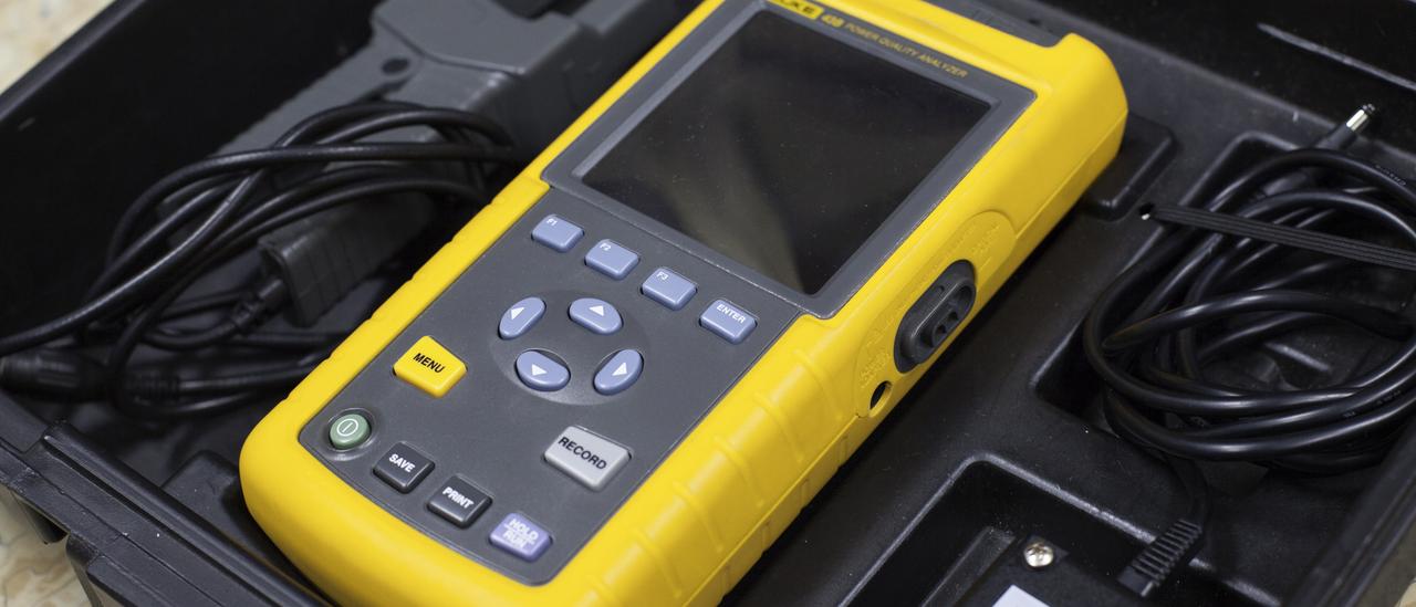 View of the FLUKE analyser in its transport case. Portable rugged device with buttons and a small screen placed in its carrying case