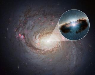 Galaxy NGC 1068 can be seen in close-up in this view from NASA's Hubble Space Telescope. This active black hole -shown as an illustration in the zoomed-in inset- is one of the most obscured known, as it is surrounded by extremely thick clouds of gas and d