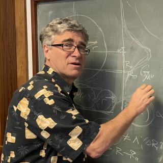 Jeffrey R. Kuhn, writing on a blackboard during his visit the IAC.