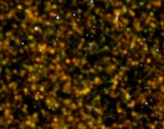 Imagen de una sección del cielo profundo de Chandra en el hemisferio norte obtenida en dos rangos espectrales complementarios: observaciones con la cámara SPIRE del Observatorio Espacial Herschel de la ESA en el infrarrojo lejano, obtenidas por el proyect 8183
