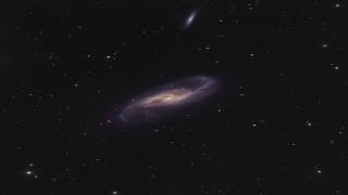 La galaxia espiral NGC 4536 presenta dos brazos muy bien definidos con algunas regiones de formación estelar. Justo encima de su núcleo amarillo, formado principalmente por estrellas viejas, dos líneas de polvo parecen cruzarse formando una X Project Image