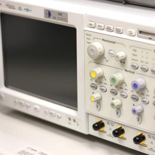 Front view of one of the special featured oscilloscopes. Apparatus with buttons, controls and indicators of different colors and a small monitor