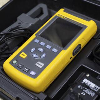 View of the FLUKE analyser in its transport case. Portable rugged device with buttons and a small screen placed in its carrying case